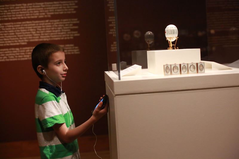 A young boy gazes at a Fabrege Egg while listening to the humanities-based educational exhibit copy. Courtesy of the OKCMOA.